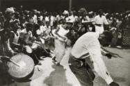 Man dancing with drummers in the background, Guinea