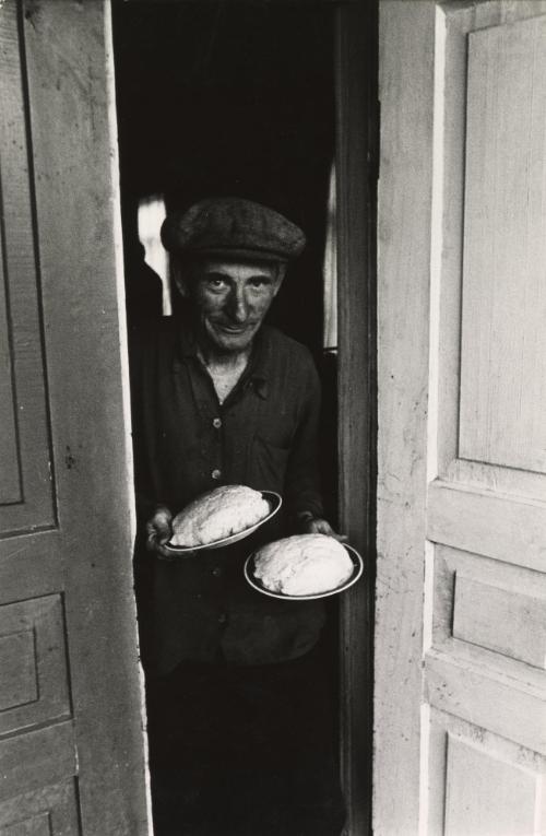 Old man holding two plates of food