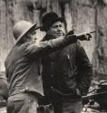 Construction worker pointing direction for man in bowler hat