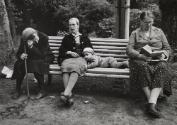 Child lying on a bench while three elderly sitting next to him, Georgia