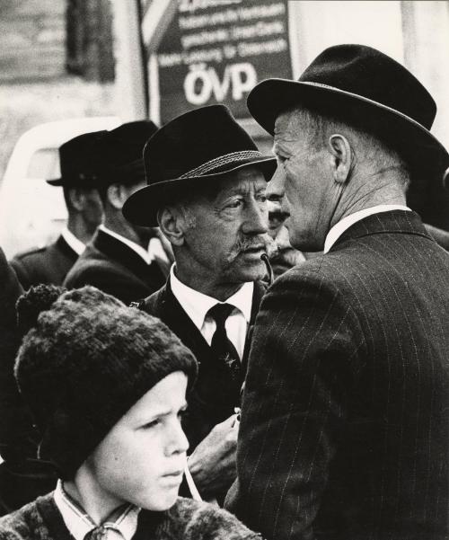 Man wearing hat and smoking pipe in crowd