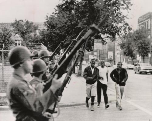 Illinois National Guard troops stand on a Chicago street in area where violent disturbances have caused death and injury the last three nights, July 15, 1966. Governor Otto Kerner called up 3,000 National Guard troops today in an attempt to halt the strife on Chicago's West Side