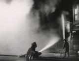 Flames of Anger: street scene of a two fire men fighting a fire with hoses during a Riot in Chicago, Illinois