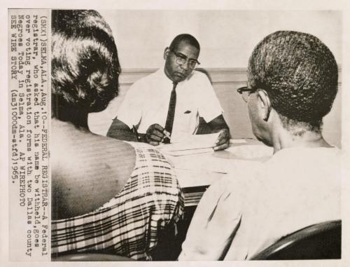 A Federal registrar, who asked that his name be withheld, goes over voting registration forms with two Dallas County African-Americans in Selma, Alabama