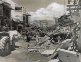 The main street of Nha Trang, a coastal town 200 miles northeast of Saigon, after an American Canberra jet loaded with 250 pound bombs crashed, killing 12 South Vietnamese and injuring 71. The pilot set the automatic controls to guide the stricken plane out to sea before he baled out, but an inshore wind swept it back over land