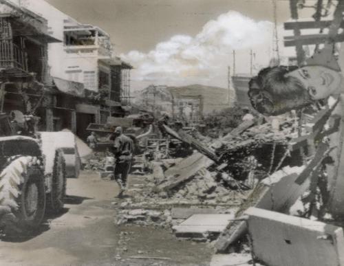 The main street of Nha Trang, a coastal town 200 miles northeast of Saigon, after an American Canberra jet loaded with 250 pound bombs crashed, killing 12 South Vietnamese and injuring 71. The pilot set the automatic controls to guide the stricken plane out to sea before he baled out, but an inshore wind swept it back over land