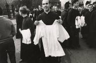 Priest holds up white shirt, Poland