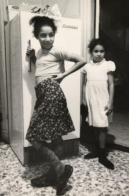 Two girls standing next to refrigerator, East Side, New York City