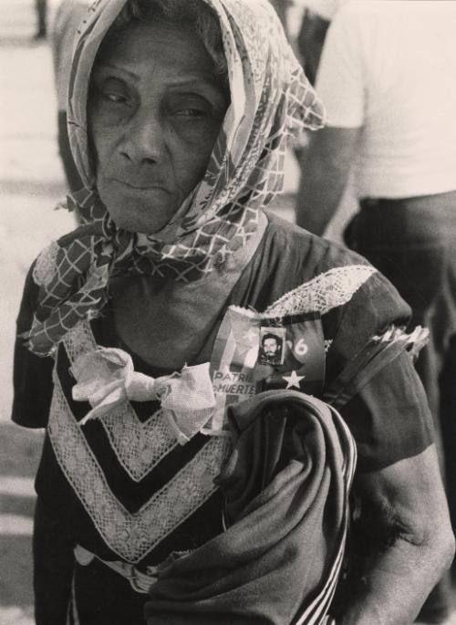 Old woman in head scarf wearing "homeland death" ribbon, Cuba