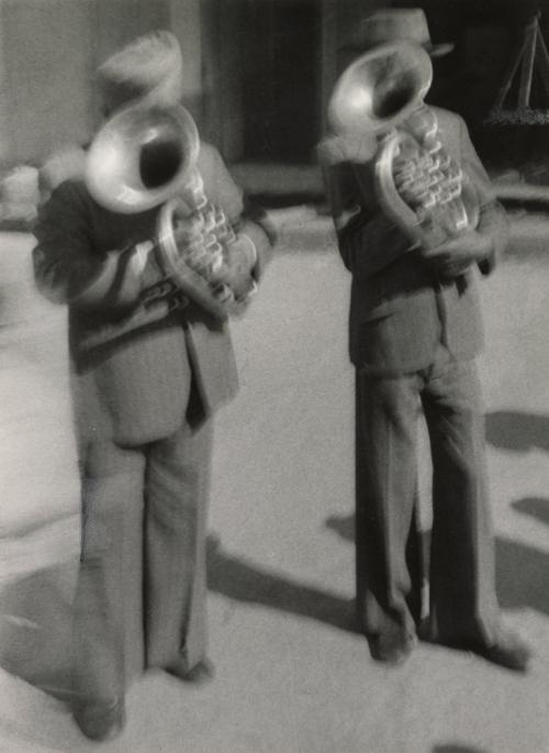 Two men playing French horns, India