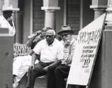 Men on street bench, Cuba