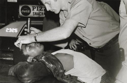 Police checking a drug addict in Times Square, NYC