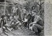 An American officer serving with the South Vietnam forces poses with group of Montagnards in front of one of their provisionary huts in a military camp in central Vietnam on November 17, 1962. They were among brought in by government troops from village where they were used as labor force by communist Viet-Cong forces. The Montagnards, dark-skinned tribesmen, numbering about 700,000 live in the highlands of central Vietnam. The Government is trying to win their alliance in its war with the Vietcong