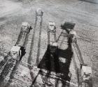 Harvesters with shadow of derrick