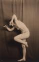 Nude with arms up, balanced on one foot