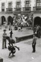 Children playing in the square in front of the Guernica City Hall, in the background a reproduction of the Picasso painting, Guernica, Spain