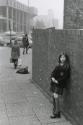Schoolgirl leaning against brick wall, Manchester, England
