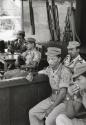Group of soldiers seated with guns behind them, Indonesia