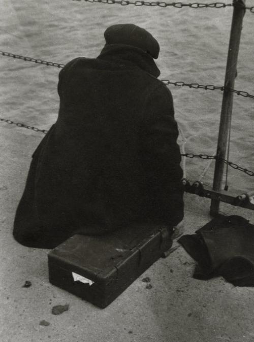 Sitting with luggage in front of water