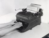 Hands typing on Remington Noiseless typewriter