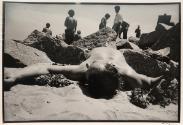 Man lying on the beach between rocks, New York, from the "Hipshot" series.