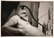 Shirtless old man sunbathing in the city, New York, from the "Hipshot" series.