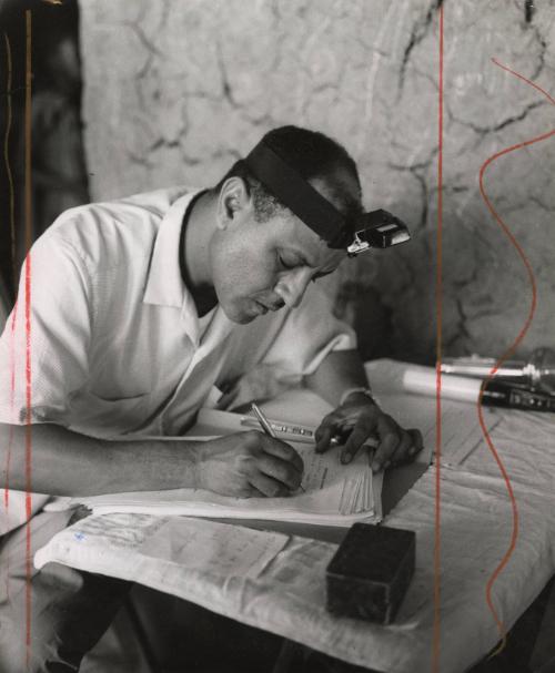 A doctor records his notes on a patient, likely Nigeria, Africa