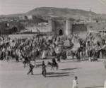 Fez, French Morocco: this series of photos shows you the old Arab City of Fez in French Morocco and the sights a tourist would see if he visited the market place in this city-narrow streets, second-hand clothes dealers, weavers, and many other things of interest. Pictured: Market day in Fez. View of part of the old market in Fez, with the Kasbah in the background, Morocco.