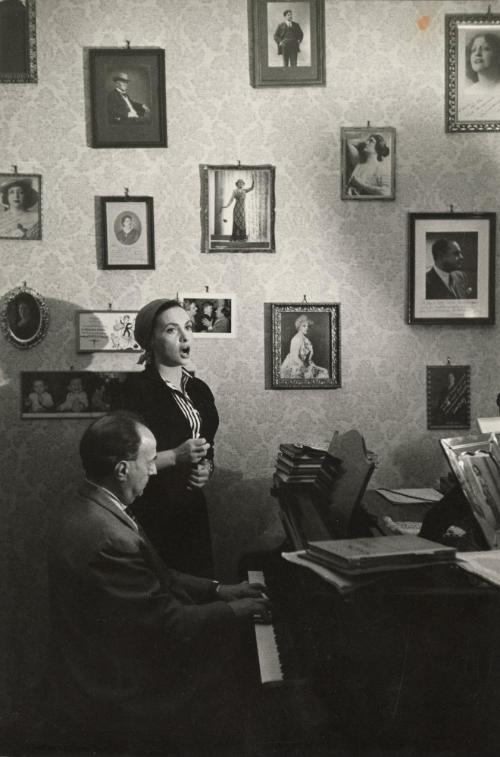 Woman singing while man plays piano