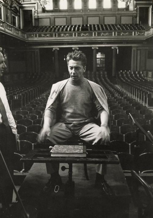 Herbert von Karajan, Austrian conductor, sitting on stage