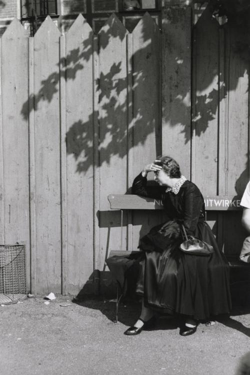 Old woman sitting on bench, Germany, 1958