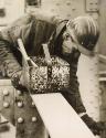 Construction worker in "Bethlehem Steel" hardhat leaning with toolbox and wrench