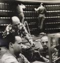 Three technicians examining wires