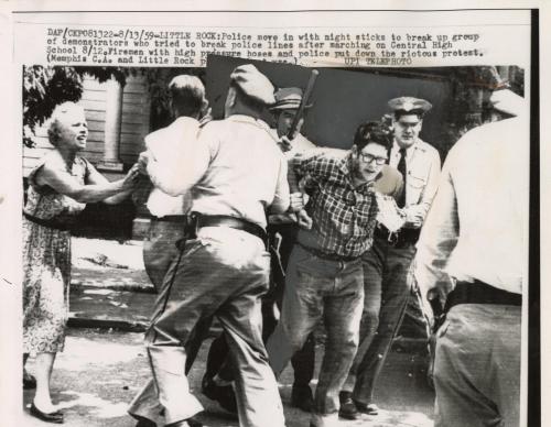 Police move in with night sticks to break up group of demonstrators who tried to break police lines after marching on Central High School August 12th. Firemen with high pressure hoses and police put down the riotous protest