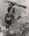 Amphibious Operation in Vietnam: up to his helmet in water but careful to keep his weapon and pack dry, a South Vietnam soldier struggled to regain his footing on a creek crossing during a major operation against the Communist Viet Cong recently in the Darlac Plateau area, about 160 miles northeast of Saigon. The sortie was carried out in heavy rain and through thick jungles in an effort to root out Communist guerrillas