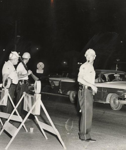 Helmeted police at roadblock at 147th Street and Wood, one of several set up to prevent outsiders and troublemakers from entering the riot-torn community of Dixmoor, Illinois. All stores in the community have agreed to close their doors at 6 p.m. and the sales of liquor and firearms in the area have been halted