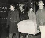 Scores of pickets marched through the Loop in silent procession Friday in protest over the fatal beating of the Reverend James Reeb in Selma, Alabama. They were led by six men bearing a gray mock coffin, which was labeled with a sign: "God-- go South." Demonstrators carried other cardboard signs. By the time the demonstrators reached the Federal Building, the procession had grown to nearly 90 people, about half Negro and half white.