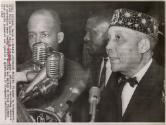 Elijah Addresses Muslims: flanked by bodyguards, Black Muslim leader Elijah Muhammad, right, addresses concluding session of convention. Final session was marked by brief violence when guards pummeled and ejected a spectator, Chicago.