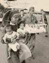 Human by-products of War: American GI and a nun carry orphans to transport plane at Pleiku. Children were evacuated to Saigon as Communist drive threatened Pleiku