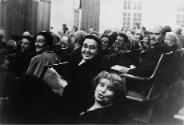 A seated audience smiling in the direction of the photographer, Poland