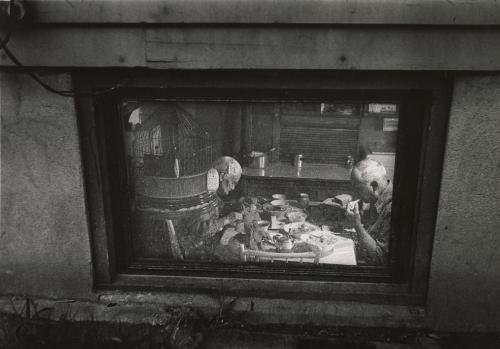 View through window of old couple seated at table