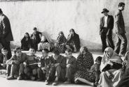 Group of veiled women seated with children outside, Iran