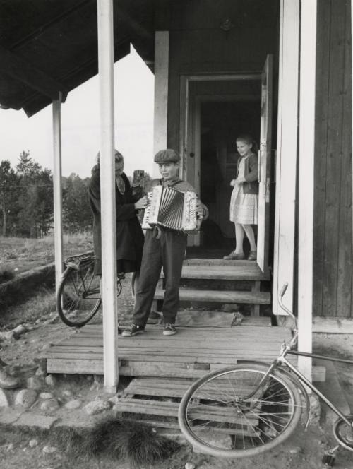 Boy playing accordion, Inari, Finland