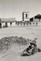 Man sitting in hole holding rope, Village of Puno, Peru