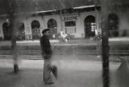 The train journey: a man in a beret waits on a station platform, Libourne, France