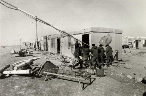 The evacuation of the Sinai by the Israelis, prior to the handing over of the territory to the Egyptians, was met with fierce resistance by the Israeli settlers. The army removed protestors before the settlements and army camps could be dismantled. The region was being returned in accordance with the Israel/Egypt peace agreements. An Israeli army camp in the process of being dismantled, soldiers take down an aerial in an "Iwo Jima" like pose