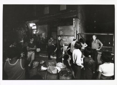 The neighborhood gathered to watch.  Somewhere within the building a man was concealed with a gun