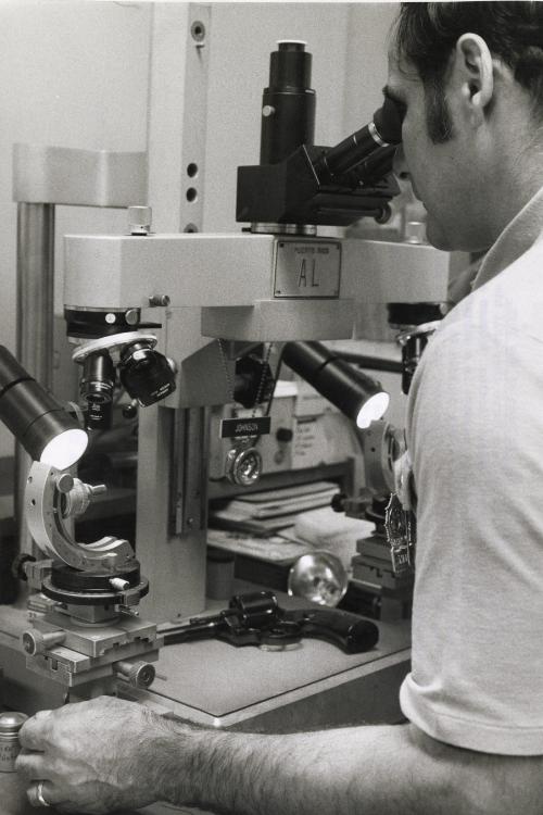 An electronic microscope takes photos of the pistol barrel. Items are microscopically tested to show indentations and markings found on the weapon and on the bullet, NYC