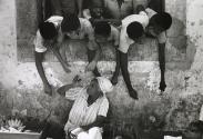 Children leaning out window towards old woman, Salvador de Bahia, Brazil