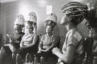 Women drying their hair in curlers at salon